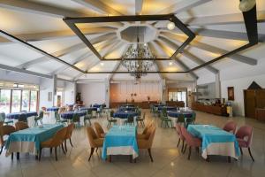 une salle à manger avec des tables et des chaises bleues et un lustre dans l'établissement Halıcı Hotel Resort & SPA, à Pamukkale