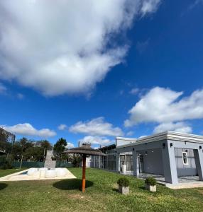 un paraguas en el césped frente a un edificio en Bitcoin s House Quinta Familiar 1000 m2 Piscina in 