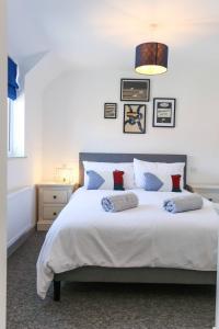 um quarto com uma grande cama branca com almofadas em Shorebreak - Bracklesham Bay Apartment em Chichester