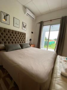 Un dormitorio con una gran cama blanca y una ventana en Bitcoin s House Quinta Familiar 1000 m2 Piscina in 