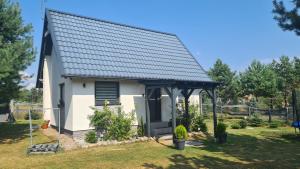 コシチェジナにあるDomek Konrad - balia ogrodowa dodatkowo płatnaの黒屋根の小さな白い礼拝堂