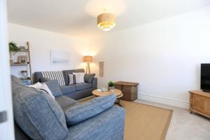 uma sala de estar com dois sofás azuis e uma mesa em 'Elements' 3 bed home in Bracklesham Bay em Chichester