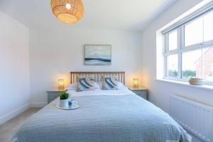 um quarto com uma cama grande e um cobertor azul em 'Elements' 3 bed home in Bracklesham Bay em Chichester