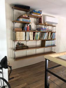 uma sala com prateleiras cheias de livros em La Grange de la Maison des chats em Saint-Amans-du-Pech