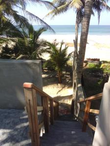 ゴールにあるUma Beach Homeのヤシの木と海のあるビーチへの階段