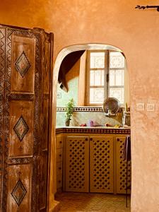 une cuisine avec un évier et une fenêtre dans l'établissement Dar Farah, riad au coeur de la médina, à Essaouira