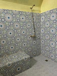 La salle de bains est pourvue d'un mur aux motifs blancs et bleus. dans l'établissement Riad Aïcha Addi - Poolside - Traditional Moroccan, à Essaouira