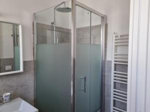 a shower with a glass door in a bathroom at Le radici in Erchie