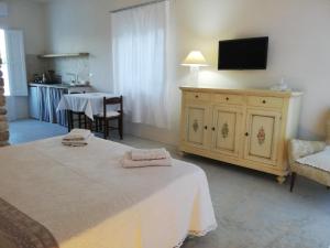 a bedroom with a bed and a tv on the wall at Holiday Home Trullo Antico in Ostuni