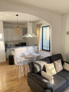 a living room with a couch and a table and a kitchen at Quimper: T3 avec vue cathédrale proche gare in Quimper