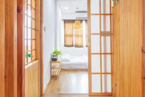 Ein Zimmer mit einer Tür, die zu einem Schlafzimmer mit einem Bett führt. in der Unterkunft HOSTIE SAIGON [WANDERLUST Home] in Ho-Chi-Minh-Stadt