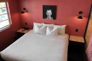 a bedroom with a large white bed with red walls at Crates at the Gaythering - Men Only in Miami Beach