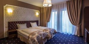 a hotel room with a bed and a large window at Hotel Bulevard in Hunedoara