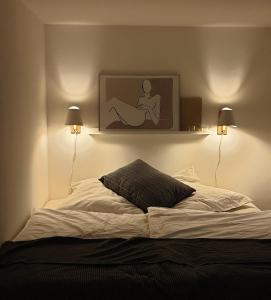 a bedroom with a bed with two lamps and a picture on the wall at Ferienwohnung Jeannette I in Hasselfelde
