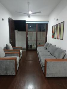 - un salon avec deux canapés et un ventilateur de plafond dans l'établissement Villa Suyara, à Panadura