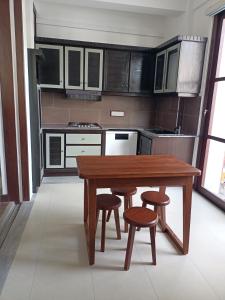 eine Küche mit einem Holztisch und Stühlen in der Unterkunft Villa Suyara in Panadura