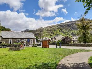 a house with a yard with a hill in the background at Bryn Afon in Caernarfon