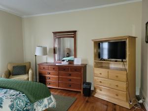 a bedroom with a bed and a dresser with a television at Brick House Retreat in Rockingham