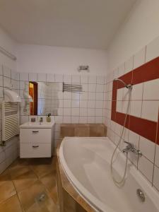 uma casa de banho branca com uma banheira e um lavatório em Palantír Panzió em Miskolc