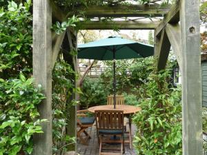 a table and chairs with an umbrella on a patio at The Old Lyme Brewhouse in Lyme Regis