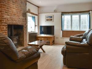 uma sala de estar com um sofá e uma lareira em The Old Lyme Brewhouse em Lyme Regis