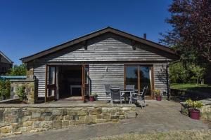 a small cabin with a table and chairs on a patio at Amber Cabin in Ashover