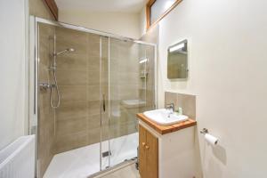 ein Bad mit einer Dusche und einem Waschbecken in der Unterkunft Amber Cabin in Ashover