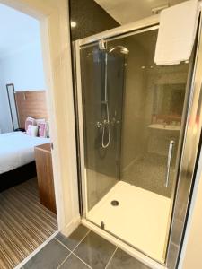 prysznic ze szklanymi drzwiami w pokoju w obiekcie "The County" w mieście Selkirk