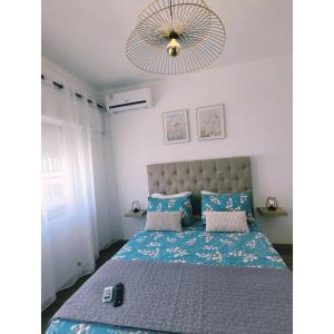a bedroom with a large bed with a blue comforter at Reis Turismo 2 in Faro