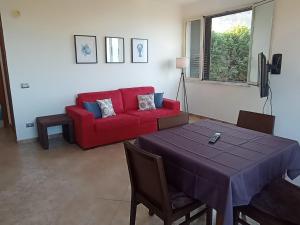 sala de estar con sofá rojo y mesa en Carmen Suite, en Cefalú