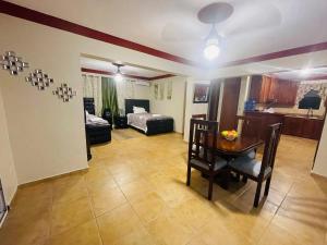 a living room with a table and a bedroom at Lovely 2 Bedroom Condo With Pool And Hot Water in Cabarete