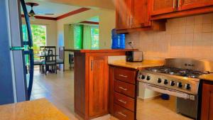 a kitchen with wooden cabinets and a stove top oven at Lovely 2 Bedroom Condo With Pool And Hot Water in Cabarete
