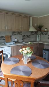 a kitchen with a wooden table with plates on it at Kaltenes Liepziedi in Roja