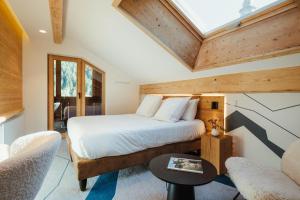 a bedroom with a bed and a couch and a table at Best Western Chalet les Saytels in Le Grand-Bornand