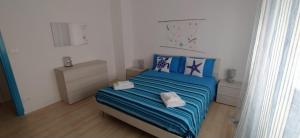 1 dormitorio con 1 cama azul y 2 toallas en Sweet Lina Holiday home, en San Remo
