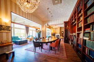 a dining room with a table and bookshelves at Bastion Hotel Apeldoorn Het Loo in Apeldoorn