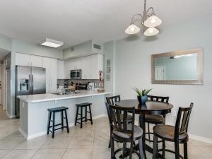 a kitchen and dining room with a table and chairs at Tidewater Orange Beach #202 in Orange Beach