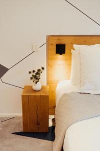 ル・グラン・ボルナンにあるベスト ウエスタン シャレー レ サイテルのベッドルーム1室(ベッド1台、植物のあるテーブル付)
