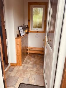 a hallway with a window and a tiled floor at The Rowanberry Suite at Rowan Cottage in Elgol