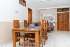 a dining room with a table and chairs at Singgahsini Jemursari in Djetak