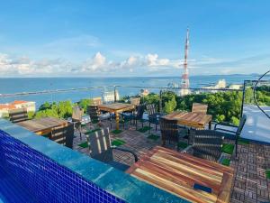 uma piscina com mesas e cadeiras e vista para o oceano em Rockmila Hotel em Duong Dong