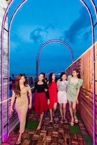 un grupo de mujeres de pie bajo un arco en un puente en Rockmila Hotel, en Phu Quoc