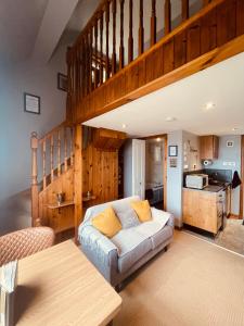 a living room with a couch and a kitchen at The Rowanberry Suite at Rowan Cottage in Elgol