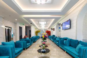 uma grande sala de espera com sofás azuis e flores em Rockmila Hotel em Duong Dong