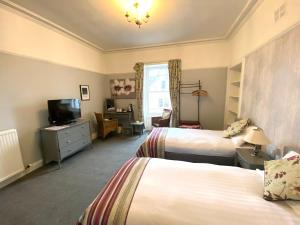 um quarto de hotel com duas camas e uma televisão em "The County" em Selkirk