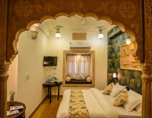 a bedroom with a large bed with an ornate ceiling at Tripli Hotels Prithvi Palace in Jaisalmer