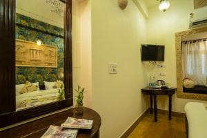 a living room with a mirror and a bed at Tripli Hotels Prithvi Palace in Jaisalmer