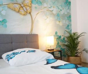 - une chambre dotée d'un lit avec un mur aux papillons dans l'établissement Mein Apartment Flowers mit Kamin, bis 10 Personen, à Frankenthal