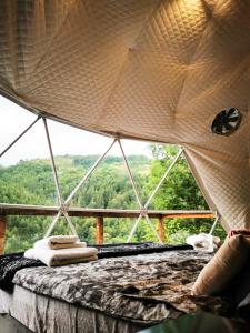 a room with a bed with a view of a forest at Apuseni Glamping Retreat in Bucium