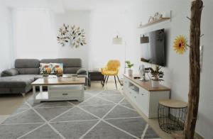 uma sala de estar com um sofá e uma mesa em Mein Apartment Flowers mit Kamin, bis 10 Personen em Frankenthal